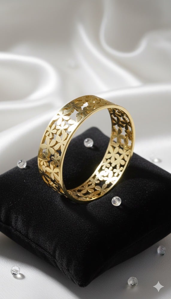 Gold and black enamel bangle on a dark surface