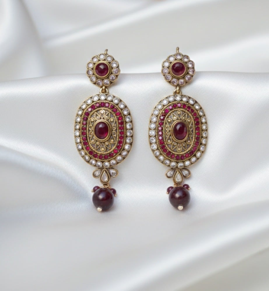 Royal Noor red kundan statement earrings on white satin